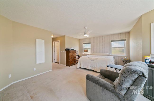 Bedroom with light carpet, ceiling fan, and wallpapered walls | Image 33