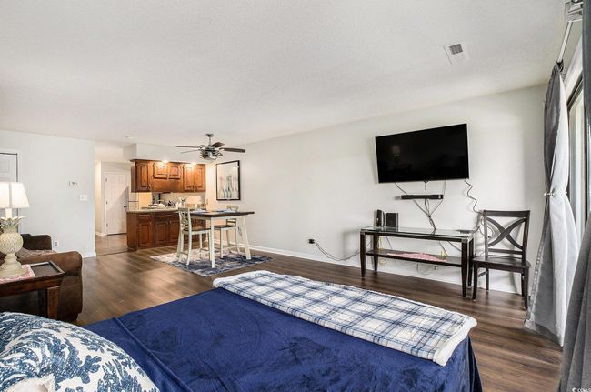 Living room with dark wood-type flooring, ceiling fan, and a textured ceiling | Image 5