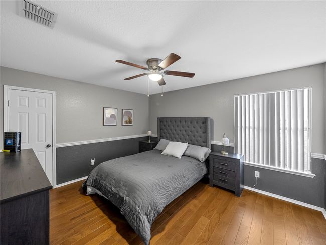 Bedroom featuring baseboards, wood finished floors, visible vents, and a ceiling fan | Image 28