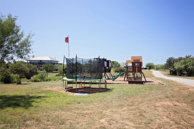 Private play area with a trampoline and a yard | Image 24