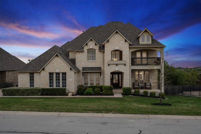 French country style house with stone siding, roof with shingles, fence, a balcony, and a yard | Image 39