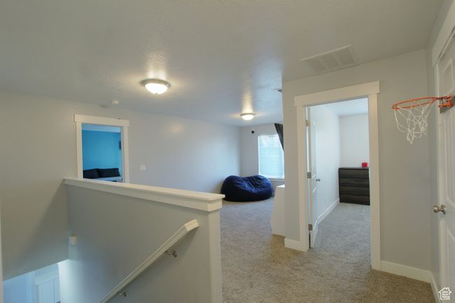 Hall featuring light carpet and an upstairs landing | Image 9