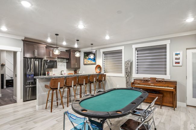 Rec room with crown molding, wet bar, recessed lighting, and light wood finished floors | Image 64