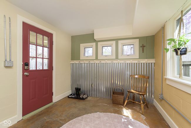 The entryway is bright and light with hooks for jackets and coats. | Image 5