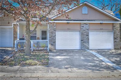 Ranch-style home with a garage and a porch | Image 1