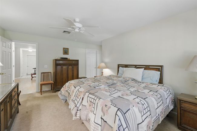 Bedroom featuring ceiling fan, light colored carpet, and visible vents | Image 14
