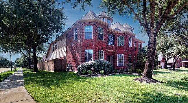 Charming corner lot home with inviting curb appeal, surrounded by lush greenery and mature trees. | Image 47