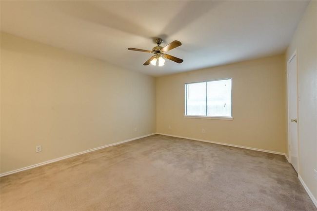 Empty room with carpet floors, ceiling fan, and baseboards | Image 11