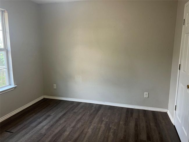 Spare room featuring dark wood finished floors and baseboards | Image 5