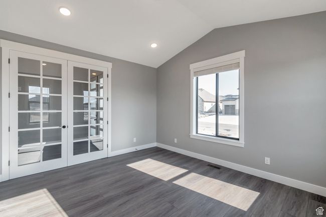 Spare room with french doors, dark wood-type flooring, vaulted ceiling, and recessed lighting | Image 9
