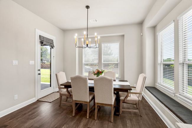 Dining area with dark wood-style flooring, a chandelier, and plenty of natural light | Image 17