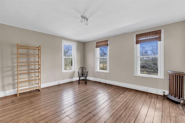 Unfurnished room featuring radiator, baseboards, and wood finished floors | Image 18