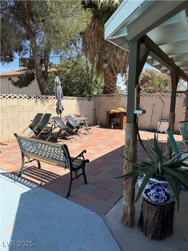 Fenced backyard with a patio area | Image 13
