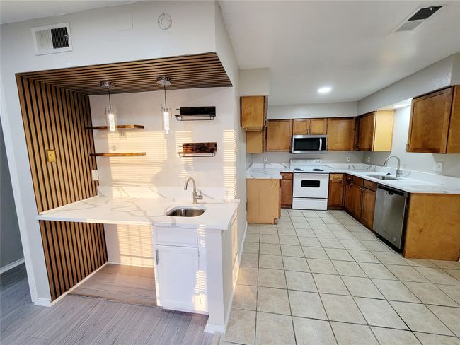 Kitchen with hanging light fixtures, stainless steel appliances, and sink | Image 5