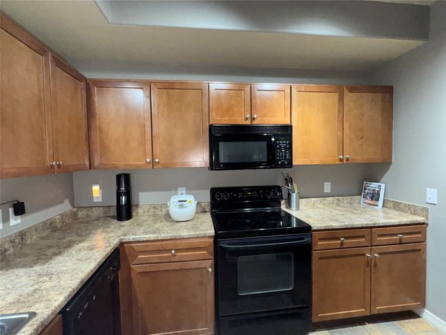 Kitchen featuring light stone countertops and black appliances | Image 31