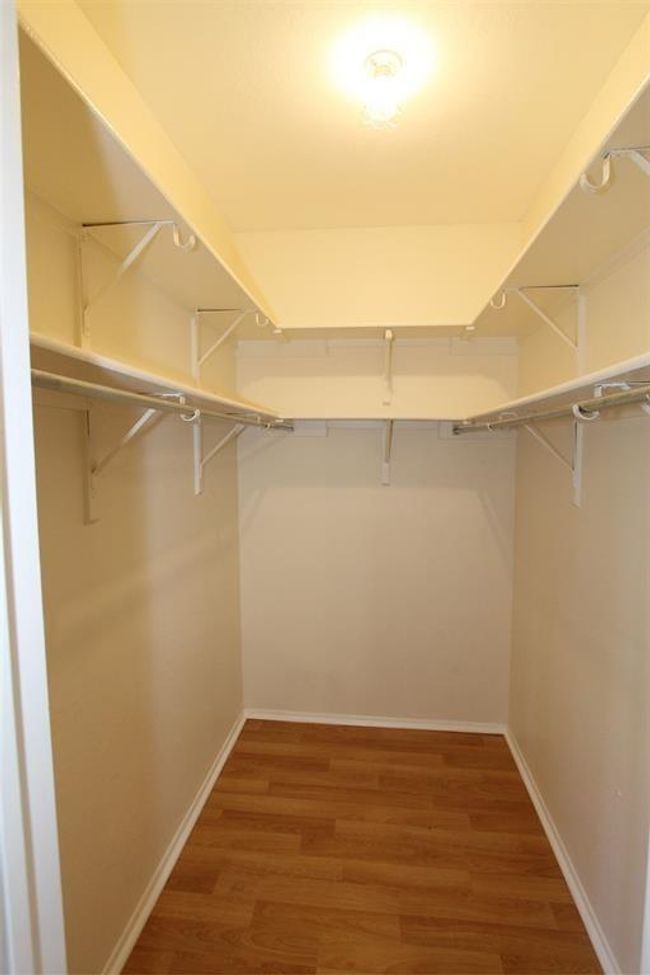 Spacious closet with wood finished floors | Image 9