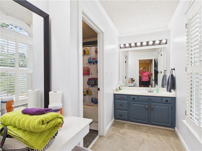 Primary bathroom features an entrance area with a makeup table and sink. | Image 29