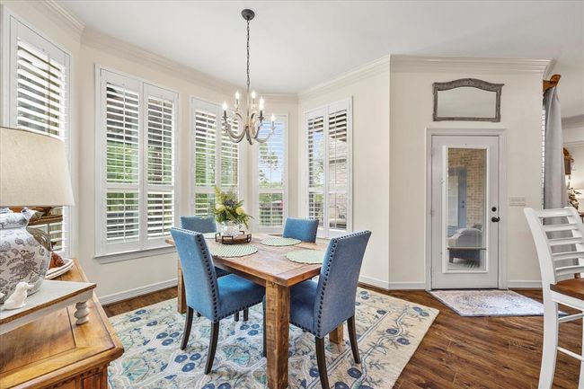 Dining area featuring ornamental molding, hardwood / wood-style flooring, and an inviting chandelier | Image 21