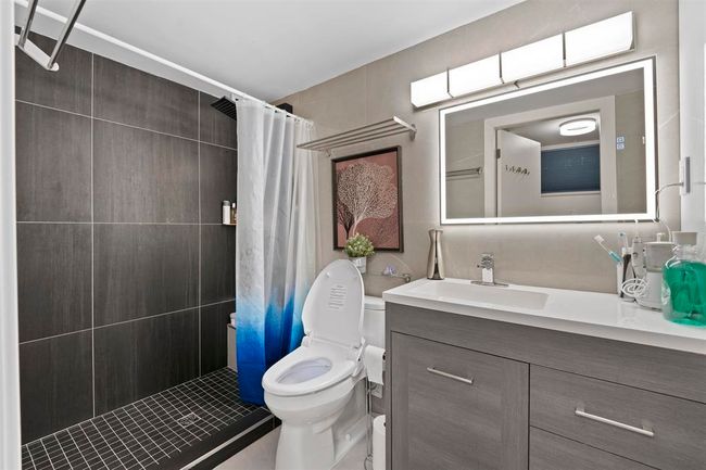 Bathroom with vanity, toilet, and tiled shower | Image 9