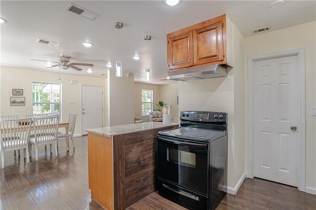 Kitchen featuring black electric range, ceiling fan, a wealth of natural light, and dark hardwood / wood-style floors | Image 27