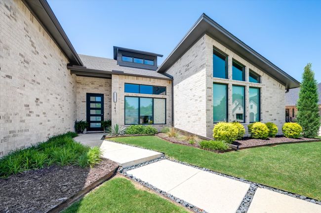 Doorway to property featuring a lawn and brick siding | Image 6
