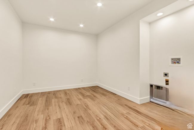 Washroom featuring recessed lighting, hookup for an electric dryer, light wood-type flooring, hookup for a washing machine, and baseboards | Image 31