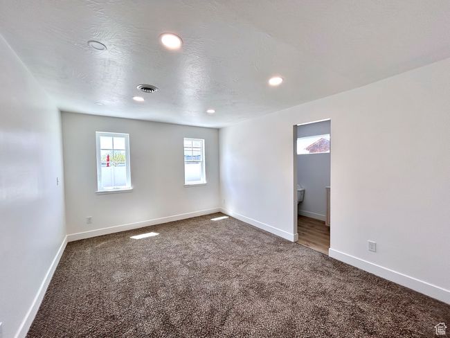 Carpeted empty room featuring recessed lighting, visible vents, and baseboards | Image 8