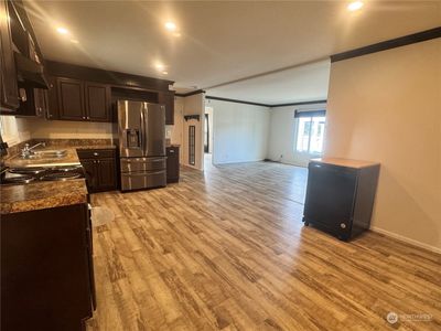 A wonderful open concept home, the kitchen flows into the living room. Notice the luxury vinyl plank flooring that's featured throughout the home. | Image 2