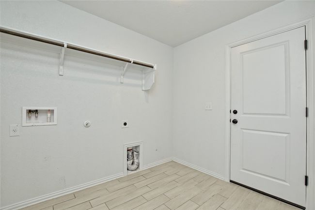 Laundry area with baseboards, light wood-type flooring, washer hookup, laundry area, and hookup for an electric dryer | Image 23