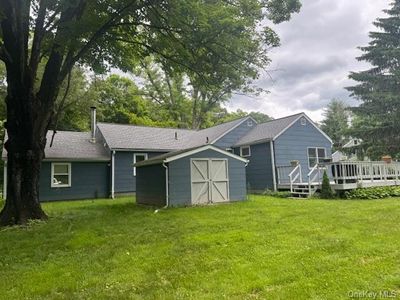 Rear view of property with a storage shed, a wooden deck, and a yard | Image 2