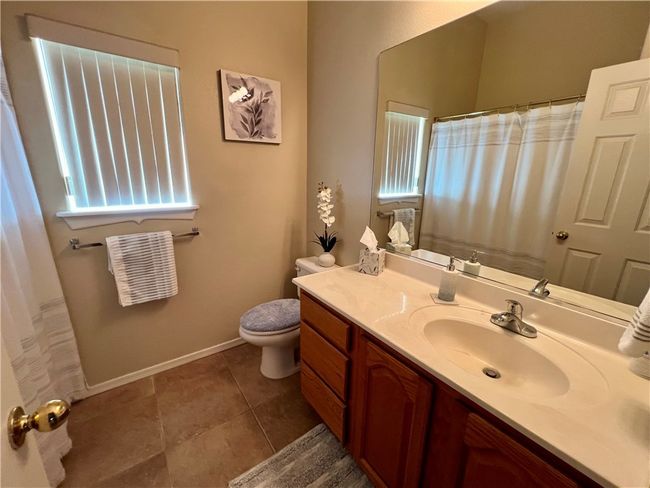 Bathroom featuring vanity, toilet, tile patterned flooring, baseboards, and a shower with curtain | Image 28