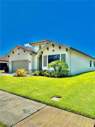 Mediterranean / spanish-style home featuring a garage and a front yard | Image 1