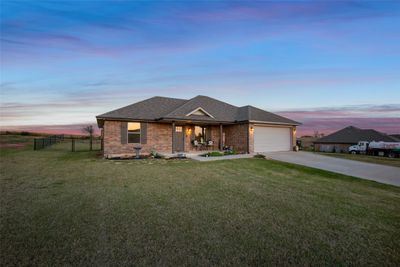 View of front facade featuring a lawn and a garage | Image 1