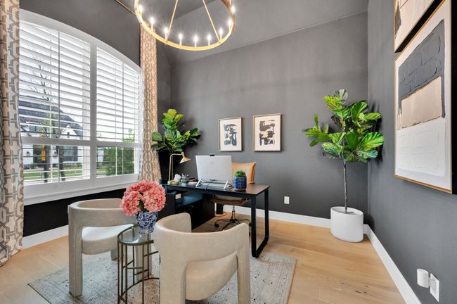 Office area with wood finished floors and a chandelier | Image 5