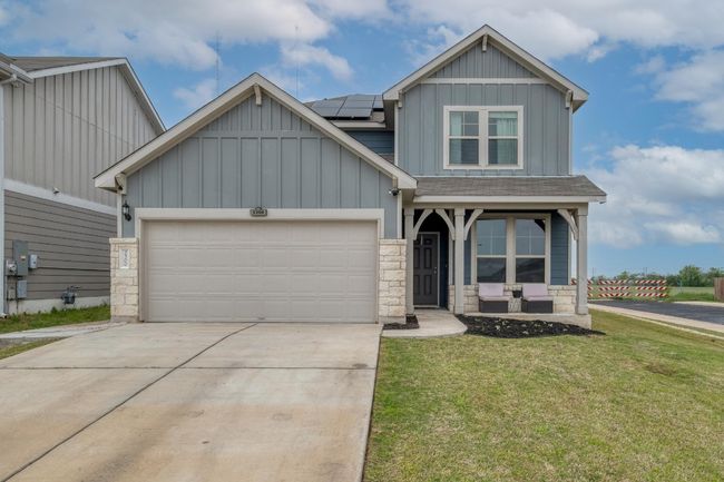 Craftsman house featuring stone siding, board and batten siding, a front yard, and roof mounted solar panels | Image 4