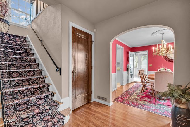 foyer featuring stairs, an inviting chandelier, arched walkways, visible vents, and light wood-style flooring | Image 10