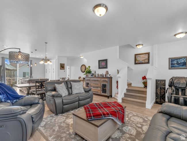 Living area featuring stairway, light wood-type flooring, and a chandelier | Image 5