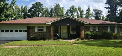 This is a single-story, brick-front home with a one-car garage and a well-maintained lawn, set in a neighborhood with mature trees. | Image 1