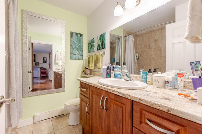 Full bathroom with baseboard heating, tile patterned flooring, vanity, and a shower with curtain | Image 13