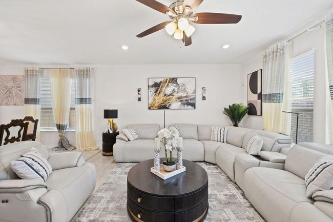 Living room with ceiling fan, light wood-style flooring, ornamental molding, and recessed lighting | Image 16