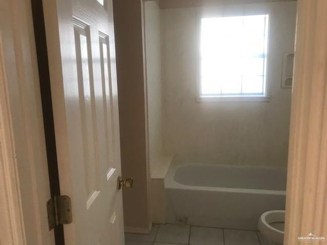 Bathroom with toilet, tile flooring, and shower / bathing tub combination | Image 4