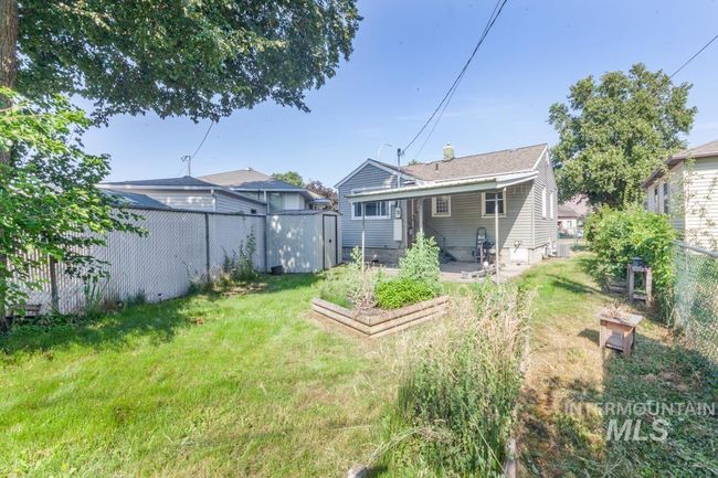 Back of property featuring a fenced backyard, a garden, a storage shed, and a patio | Image 17