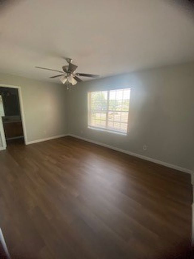 Spare room with dark wood-style flooring, baseboards, and ceiling fan | Image 28