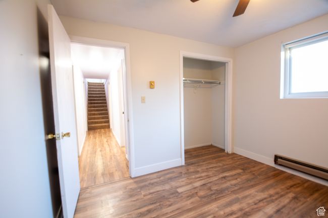 Unfurnished bedroom with baseboard heating, a closet, ceiling fan, and dark hardwood / wood-style flooring | Image 15