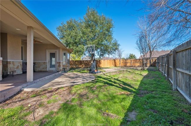 Fenced backyard with a patio and ceiling fan | Image 27