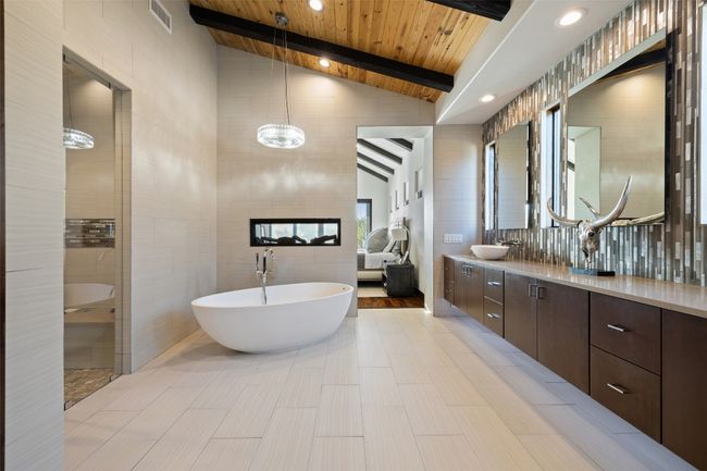 Full bath with tile walls, a freestanding tub, double vanity, wooden ceiling, and a walk in shower | Image 12