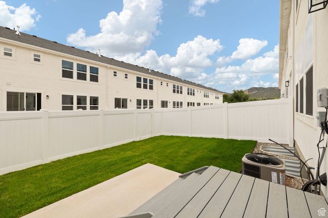 Fenced backyard with a patio area | Image 36