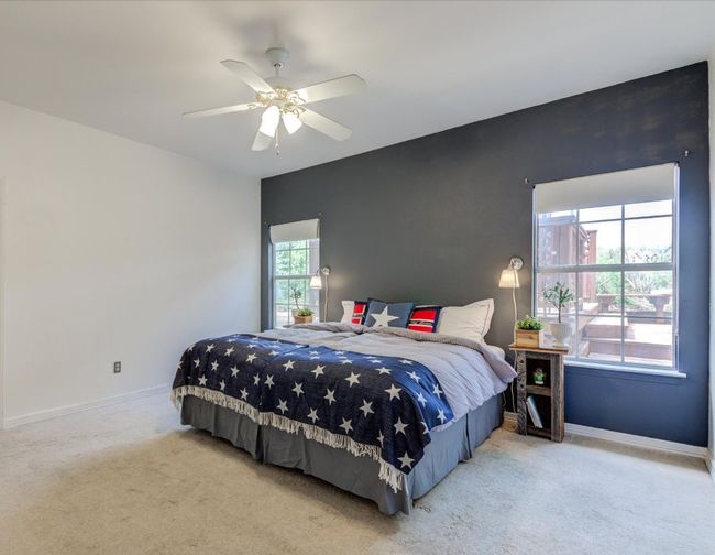 The primary bedroom features a lovely accent wall, views of the back deck and ensuite bathroom. Primary bedroom is downstairs. | Image 10