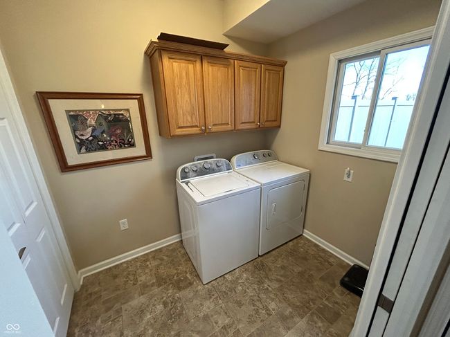 clothes washing area featuring cabinet space, stone finish floor, washing machine and clothes dryer, and baseboards | Image 20