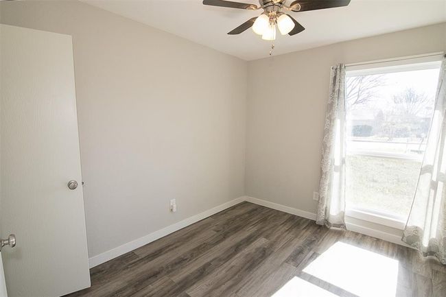 Unfurnished room with dark wood-style floors and a ceiling fan | Image 12